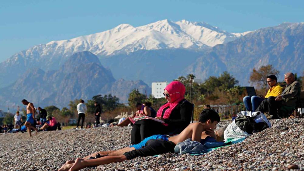 Antalya’da karla kaplı dağların gölgesinde deniz ve güneş keyfi
